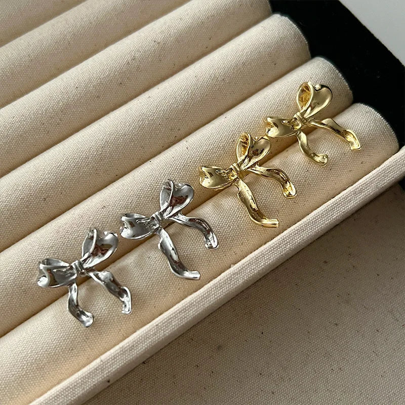 Imagine a delightful pair of earrings that exude charm and elegance. These drop earrings are designed in the shape of a sweet bow knot, giving them a playful yet sophisticated appearance. The earrings are lightweight and hang gracefully, swaying gently as you move.