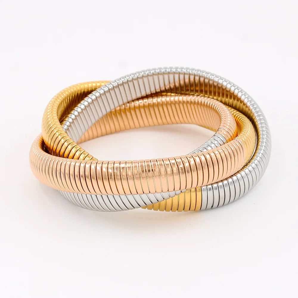 The image depicts a stylish bracelet with a ribbed design in a shiny rose gold color, suggesting it is made of 18k gold plated titanium. The bracelet features a twisted, interwoven appearance, giving it a unique and fashionable look. It appears to be a single, continuous band without clasps, showcasing its design.