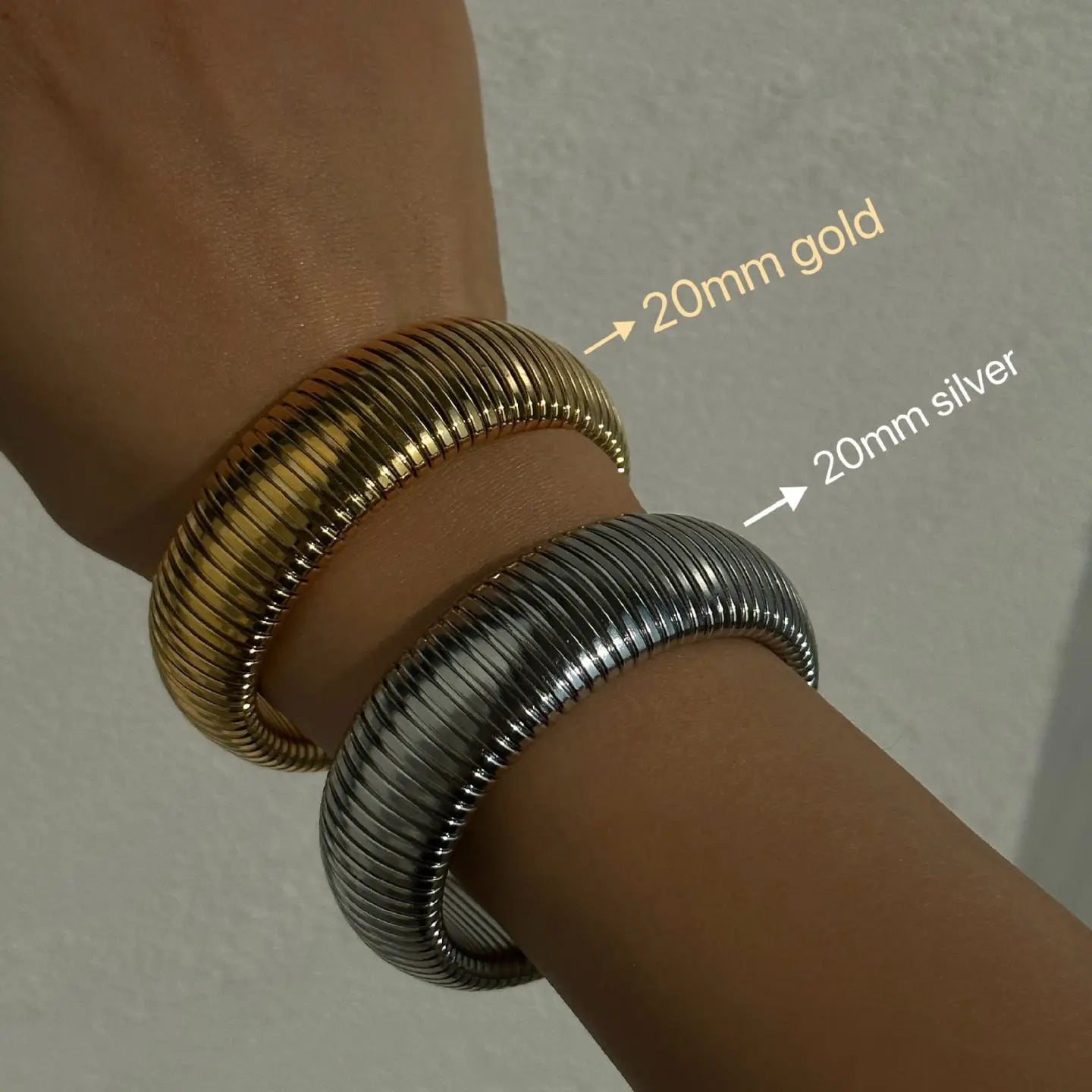 The image depicts a stylish bracelet with a ribbed design in a shiny rose gold color, suggesting it is made of 18k gold plated titanium. The bracelet features a twisted, interwoven appearance, giving it a unique and fashionable look. It appears to be a single, continuous band without clasps, showcasing its design.